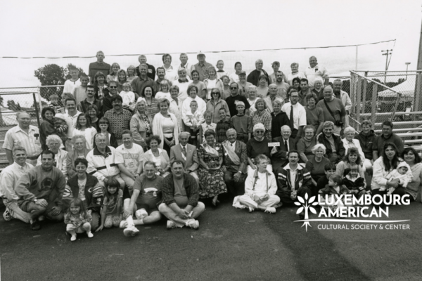 Black and white photo of a large family posing, seated on bleechers