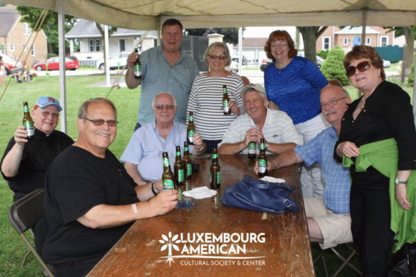 Group of people surrounding a table posing with bottles of Bofferding