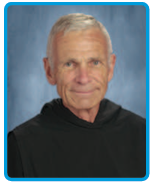 Abbot Joel Rippinger smiling in front of a blue backdrop