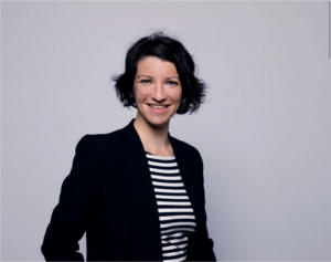 Young woman with short hair smiling at the camera.